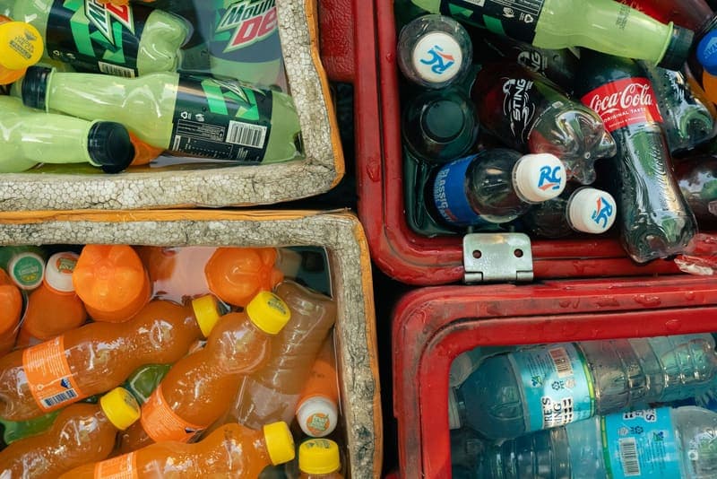 Chilled drinks packed in ice inside open outdoor coolers