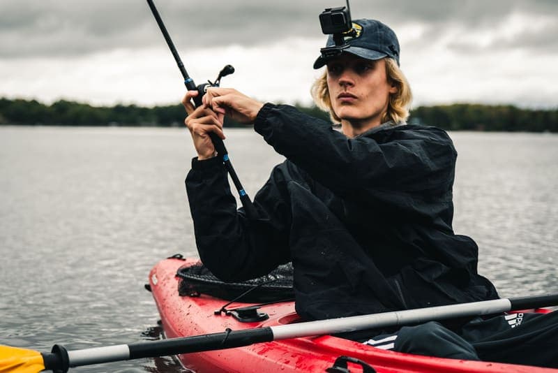 An angler fishing from a kayak with a camera mounted on his cap