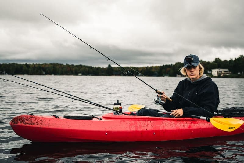 An angler fishing from a kayak on a calm lake
