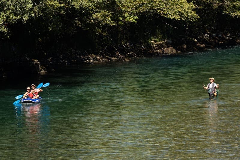 People kayaking and fishing on a calm river