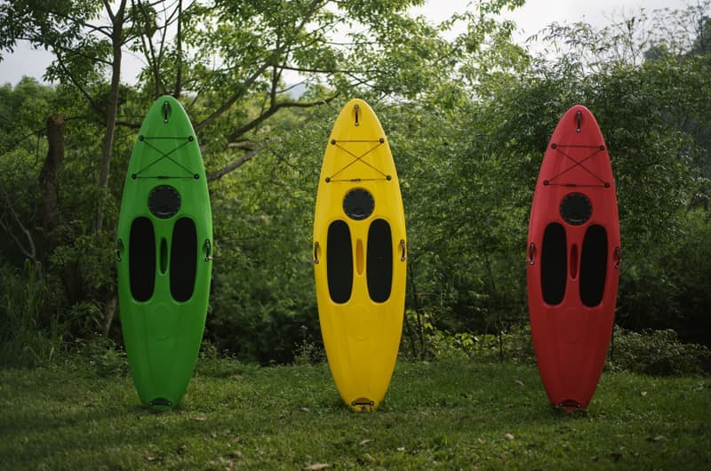 A kayak resting on grass beside a lake