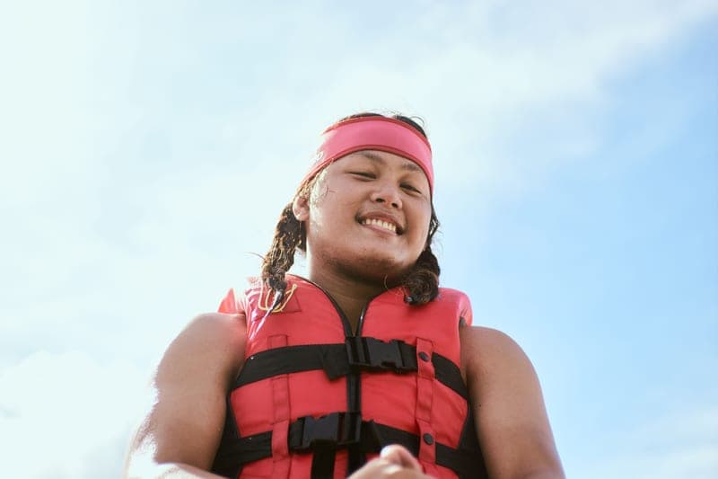 A person adjusting the strap of a life vest