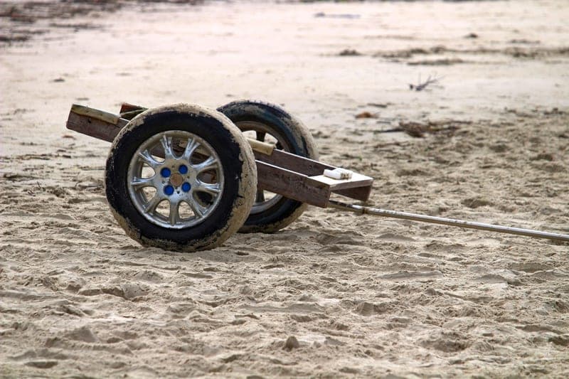Cart wheels on a sandy shoreline