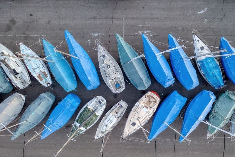 Boats under fitted blue covers, seen from directly above