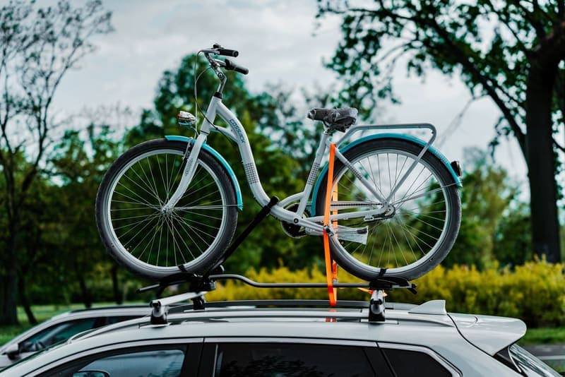 A bicycle mounted to the crossbars of a car roof rack