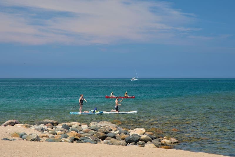 A kayak and a paddle board on the water together