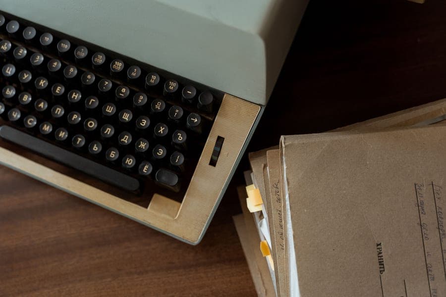 A typewriter and sheets of paper on a desk