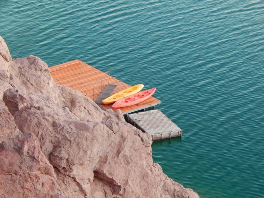 A kayak tied up at a dock on a calm morning